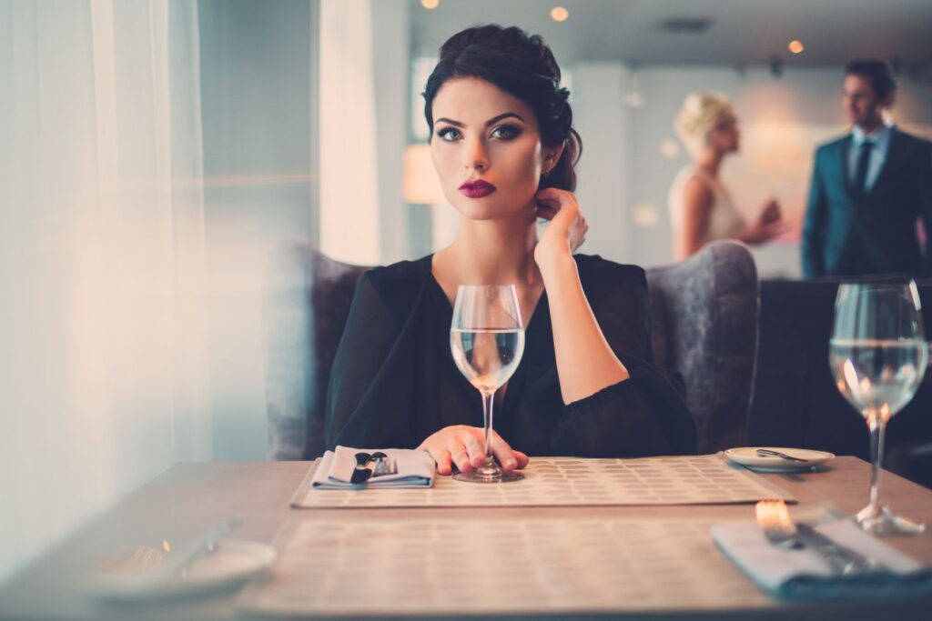 Selbstbewusste Frau beim stilvollen Dinner – ein typischer Moment für alle, die über Escort werden nachdenken.